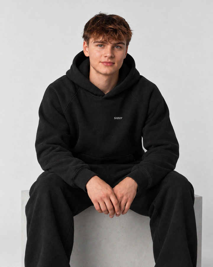 Noah in the black hoodie, sitting, pre-production visual
