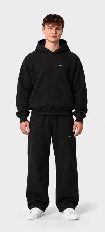 Noah in the Drop 01 hoodie and joggers, pre-production visual. Drag or use the arrow keys to turn him.